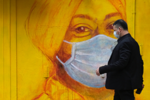 A man with protective mask walks on the street, following the novel coronavirus disease (COVID-19) outbreak, in Hong Kong, China March 27, 2020. REUTERS/Tyrone Siu