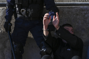 Des agents de la police anti-émeute retiennent un manifestant lors d'une manifestation d'étudiants universitaires contre les législateurs qui s'apprêtent à approuver un plan créant une force de police spéciale pour lutter contre la violence endémique dans les universités, à Athènes le 10 février 2021. Quelque 5 000 étudiants se sont rassemblés à Athènes, selon une source policière, malgré l'interdiction récente des manifestations de plus de 100 personnes pour endiguer la propagation de la pandémie de coronavirus.