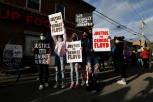 Children hold signs while people react after the verdict in the trial of former Minneapolis police officer Derek Chauvin, found guilty of the death of George Floyd, at George Floyd Square in Minneapolis, Minnesota, U.S., April 20, 2021. REUTERS/Octavio Jones