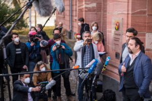 L'avocat Patrick Kroker (2eR) et le co-plaignant Wassim Mukdad (R) s'entretiennent avec les médias devant la cour après le verdict du procès d'un accusé syrien accusé de crimes contre l'humanité dans le premier procès de ce type à émerger du conflit syrien, le 24 février 2021 à Coblence, en Allemagne occidentale. - Eyad al-Gharib, 44 ans, ancien agent des services de renseignement syriens, a été condamné à quatre ans et demi de prison pour complicité de crimes contre l'humanité dans le cadre du premier procès pour torture parrainé par l'État syrien.