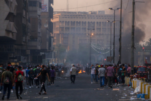 TOPSHOT - Iraqi demonstrators gather in al-Khalani square in central Baghdad on November 9, 2019, during clashes with Iraqi forces. - Iraqi forces unleashed live ammunition as they pushed towards the capital's main anti-government protest camp, after political leaders agreed to stand up the government by any means -- including force. (Photo by SABAH ARAR / AFP)