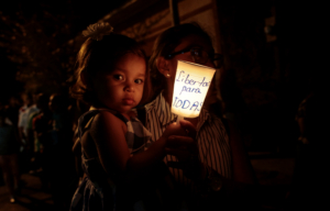 A faithful and her daughter hold a candle reading " Freedom for all political prisoners", during the procession of "El Silencio" in Masaya, Nicaragua April 18, 2019. REUTERS/Oswaldo Rivas