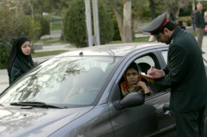 Iran - Théréan 22/04/2007 : des policiers iraniens arrêtent une voiture lors d'une opération de répression visant à faire respecter le code vestimentaire islamique dans le nord de Téhéran. L'Iran a émis plus d'un millier d'avertissements et arrêté des dizaines de personnes dans le cadre d'une nouvelle campagne visant à contraindre les femmes dont la tenue vestimentaire est jugée inappropriée à se conformer aux règles vestimentaires islamiques.
