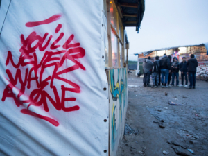 Graffiti is seen close to the entrance of the informal camp in Calais known as 'The Jungle', 23 January, 2016. An estimated 6000 refugees and migrants live in the informal camp situated to the South West of Calais.