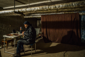Un vieil homme déjeune à l'intérieur d'un abri dans le sous-sol de sa maison dans le nord de Kharkov, en Ukraine