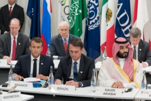 France's President Emmanuel Macron (L) sits with Brazil's President Jair Bolsonaro (C) and Saudi Arabia's Crown Prince Mohammed bin Salman as they attend a meeting on the digital economy at the G20 Summit in Osaka on June 28, 2019. (Photo by Jacques Witt / POOL / AFP)