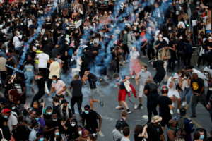 People run from tear gas as they attend a banned demonstration planned in memory of Adama Traore, a 24-year-old black Frenchman who died in a 2016 police operation which some have likened to the death of George Floyd in the United States, in front of courthouse in Paris, France June 2, 2020. REUTERS/Gonzalo Fuentes
