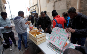 Des Volontaires distribuent de la nourriture aux migrants alors qu'ils occupent l'église Saint-Ferréol pour protester contre les conditions de vie des mineurs migrants non accompagnés à Marseille