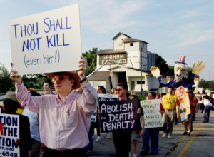 Anti-death penalty demonstrators march past the grain silo of a Terre Haute, Indiana, farm June 10, 2001 as they make their way to the Federal Penitentiary to protest the execution of Oklahoma City bomber Timothy McVeigh. McVeigh is expected to be put to death by lethal injection June 11 in the first federal execution since 1963.
