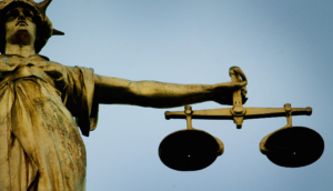 A statue holding the scales of justice is seen on top of the Old Bailey in London, December 12, 2003. REUTERS/Stephen Hird