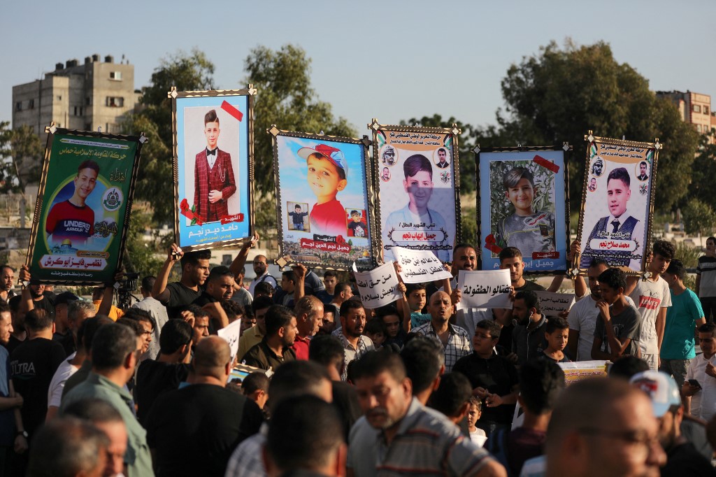 Relatives of five Palestinian children from the Najm family who were killed during the last fight between Gaza and Israel, during a rally next to their graves, in Jabalia in the northern of Gaza strip on August 16, 2022. Israel admitted responsibility for killing five Palestinian children in an air strike on the Fallujah cemetery in the town of Jabalia, in the northern Gaza Strip, on 7 August, after it had initially claimed they were killed as a result of a missile fired by Islamic Jihad, accroding to reported Israeli Haaretz newspaper.  (Photo by Majdi Fathi/NurPhoto) (Photo by MAJDI FATHI / NurPhoto / NurPhoto via AFP)