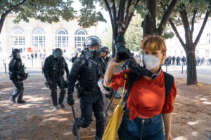The photographer Marie Rouge is pushed back and kept at a distance by riot police so as not to take pictures of a protester s arrest. Demonstration by hospital and emergency staff to demand more human and financial resources to defend the hospital. Paris, France, Tuesday 16 June 2020. Photograph by Amaury Cornu / Hans Lucas.
La photographe Marie Rouge repoussee et tenue a distance par des policiers anti emeutes pour ne pas prendre d images d une arrestation d un manifestant. Manifestation des personnels soignants des hopitaux et des urgences pour reclamer plus de moyens humains et financiers pour la defense de l hopital au depart du Ministere de la Sante. Paris, France, Mardi 16 Juin 2020. Photographie de Amaury Cornu / Hans Lucas.