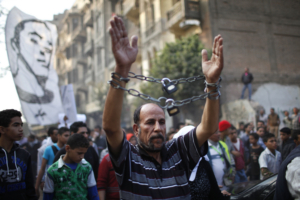 A mourner wearing chains attends the funeral of youth activist Gaber Salah, also known as Gika, at Tahrir in Cairo November 26, 2012. State news agency MENA reported that Salah, a member of the 6th of April youth movement, was wounded with birdshot in the head, neck, chest and arms and put on life support in intensive care, following last Monday's clashes between police and protesters on the anniversary of lethal street violence between activists and security.