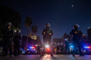 Police officers hold a line in front of LA City Hall during a protest demanding justice for George Floyd, Breonna Taylor and also in solidarity with Portland's protests, in Downtown Los Angeles, California, on July 25, 2020. (Photo by Apu GOMES / AFP)