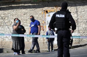 People wearing protective face masks are pictured as a police officer looks on while the coronavirus disease (COVID-19) spreads in the area around Roma settlements, in Zehra, Slovakia April 9, 2020.
