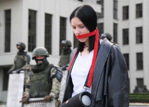 6308398 14.08.2020 A woman stands in front of members of Belarusian Interior Ministry troops as she attends an opposition demonstration to protest against police violence and to reject the presidential election results near the Government House in Independence Square in Minsk, Belarus. Viktor Tolochko / Sputnik