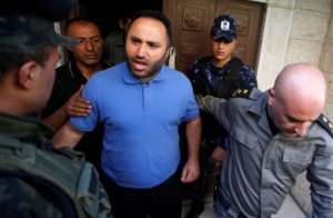 Activist Issa Amro is escorted by members of Palestinian security forces as he leaves a court in the West Bank city of Hebron September 7, 2017. REUTERS/Mussa Qawasma