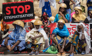 Des femmes tiennent une pancarte avec une inscription "stop à la stigmatisation" alors que des centaines de personnes ont manifesté le 22 juin 2019 devant le palais de justice de Ouagadougou pour réclamer "vérité et justice" pour les victimes de Yirgou, une localité du nord du Burkina Faso où les représailles contre la communauté peul, après une attaque terroriste, ont fait 49 morts le 1er janvier.