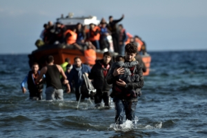 Refugees and migrants arrive on the Greek Lesbos island after crossing the Aegean Sea from Turkey on November 7, 2015. Nearly 500 people have died trying to cross the Aegean Sea from neighbouring Turkey this year, many of them in the narrow but treacherous stretch separating Lesbos from Turkey. AFP PHOTO / ARIS MESSINIS (Photo credit should read ARIS MESSINIS/AFP via Getty Images)