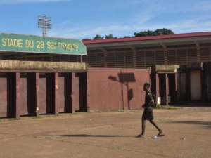A man walks past the entrance to the Stadium of the 28th September in Conakry on September 26, 2022 on the eve of the opening of the trial of eleven men accused of being responsible for the massacre of over 150 protesters at the same stadium in 2009. - Countless Guineans have waited 13 years for the trial of former junta leader Moussa Dadis Camara and others held responsible for an appalling massacre committed on September 28, 2009. That time has come. Victims and relatives will head on Wednesday to a brand-new court in Conakry, where the trial of Captain Camara and 10 former officials will open, barring a last-minute adjournment. (Photo by CELLOU BINANI / AFP) (Photo by CELLOU BINANI/AFP via Getty Images)