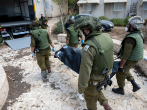 KFAR AZA, ISRAEL - OCTOBER 10: IDF soldiers remove the body of civilians who were killed days earlier in an attack by Hamas armed groups on this kibbutz near the border with Gaza, on October 10, 2023 in Kfar Aza, Israel. (Photo by Alexi J. Rosenfeld/Getty Images)