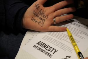 Un hashtag Nous sommes toutes uni.e.s écrit sur la main d'une femme