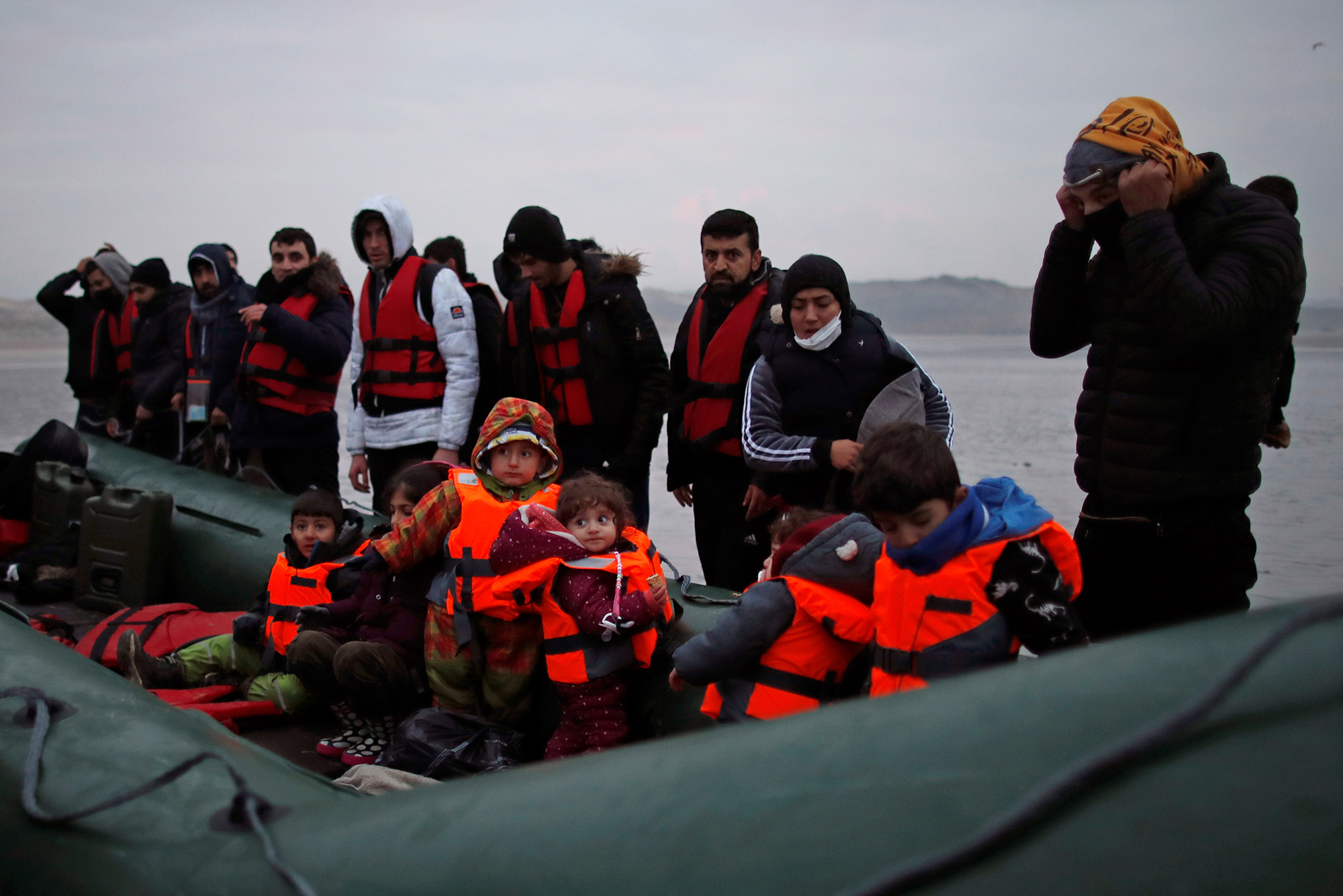 Un groupe de plus de 40 migrants avec des enfants monte à bord d'un canot pneumatique alors qu'ils quittent les côtes du nord de la France pour traverser la Manche, près de Wimereux, France. Photo prise le 24 novembre 2021