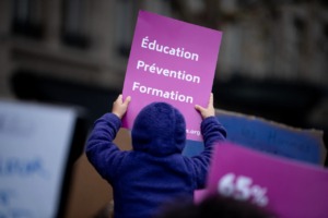 Droits des femmes- un enfant lit une affiche portant sur l'Education aux droits des femmes