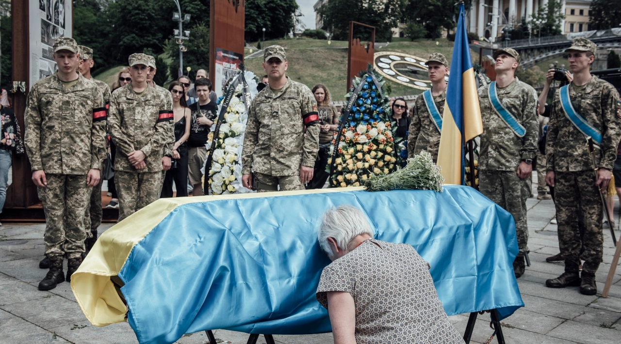 Une femme pleure sur le cercueil de Roman Ratouchny, figure du mouvement citoyen Euromaïdan en 2014. Roman est mort au combat début juin. Kyiv, le samedi 18 juin 2022.