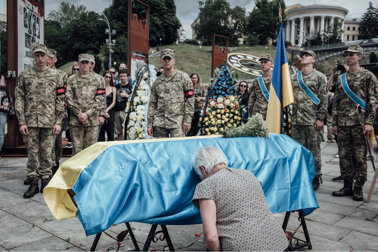 Une femme pleure sur le cercueil de Roman Ratouchny, figure du mouvement citoyen Euromaïdan en 2014. Roman est mort au combat début juin. Kyiv, le samedi 18 juin 2022.