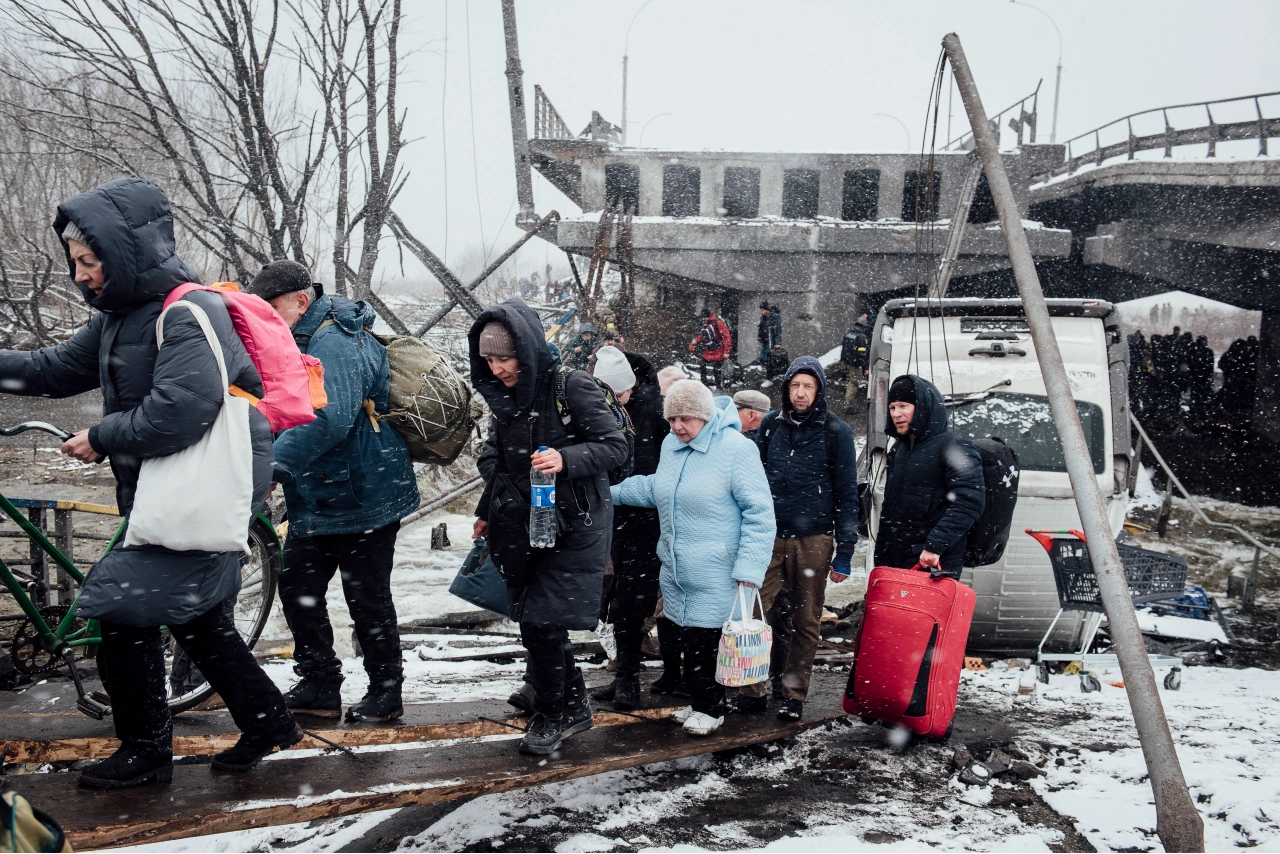 Le 8 mars 2022, à Irpin. Des civils ukrainiens fuient la ville alors que les combats s’intensifient. Les soldats ukrainiens ont détruit, par mesure de précaution, le pont reliant Irpin à Kyiv. Des milliers de civils empruntent ce point de passage pour échapper aux affrontements.